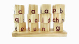 Wooden alphabet blocks, likely part of a spelling or letter-matching game for children